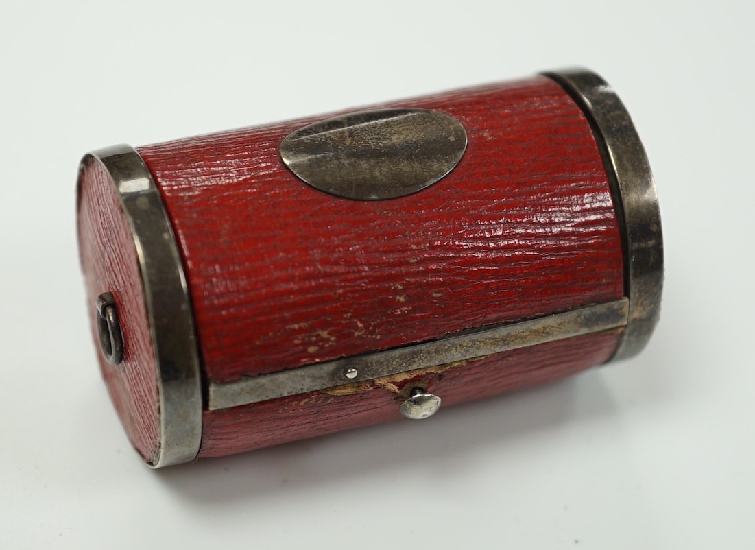A rare Regency morocco leather mounted white metal cylindrical ring box containing five pinchbeck/base metal sample rings, box length 47mm.